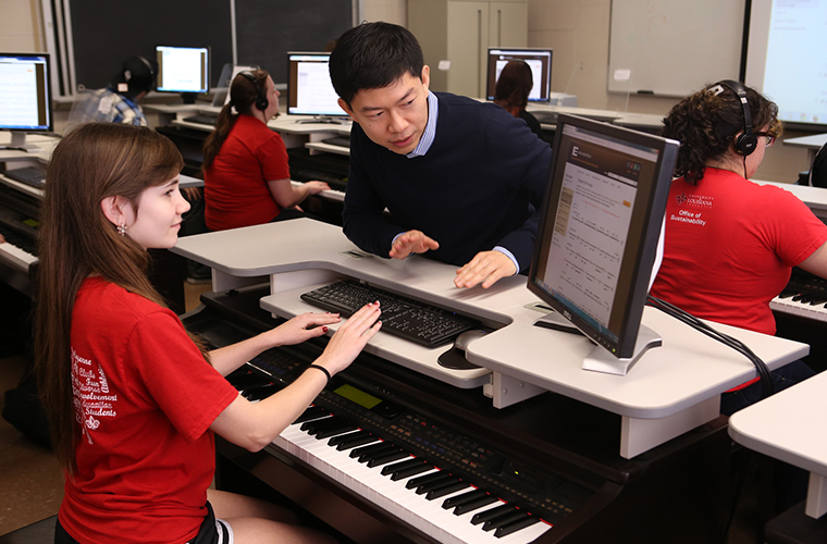 student and professor composing music on a piano
