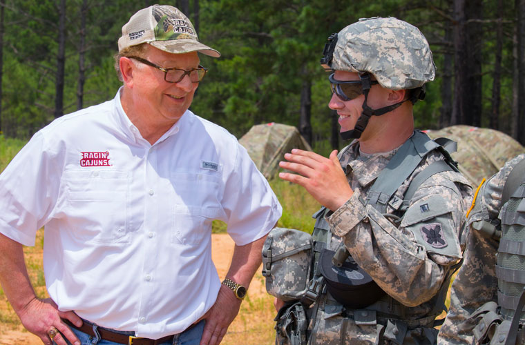 A national guard soldier talking to University of Louisiana at Lafayette president Joseph Savoie