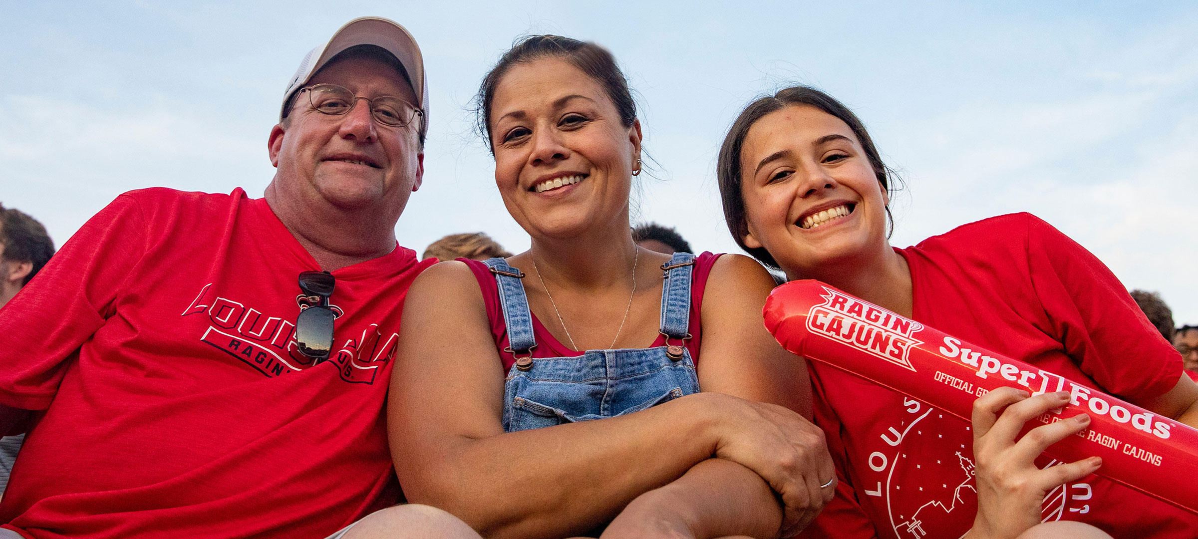 A UL Lafayette student with her parents in the stands at a Louisiana Ragin' Cajuns football game