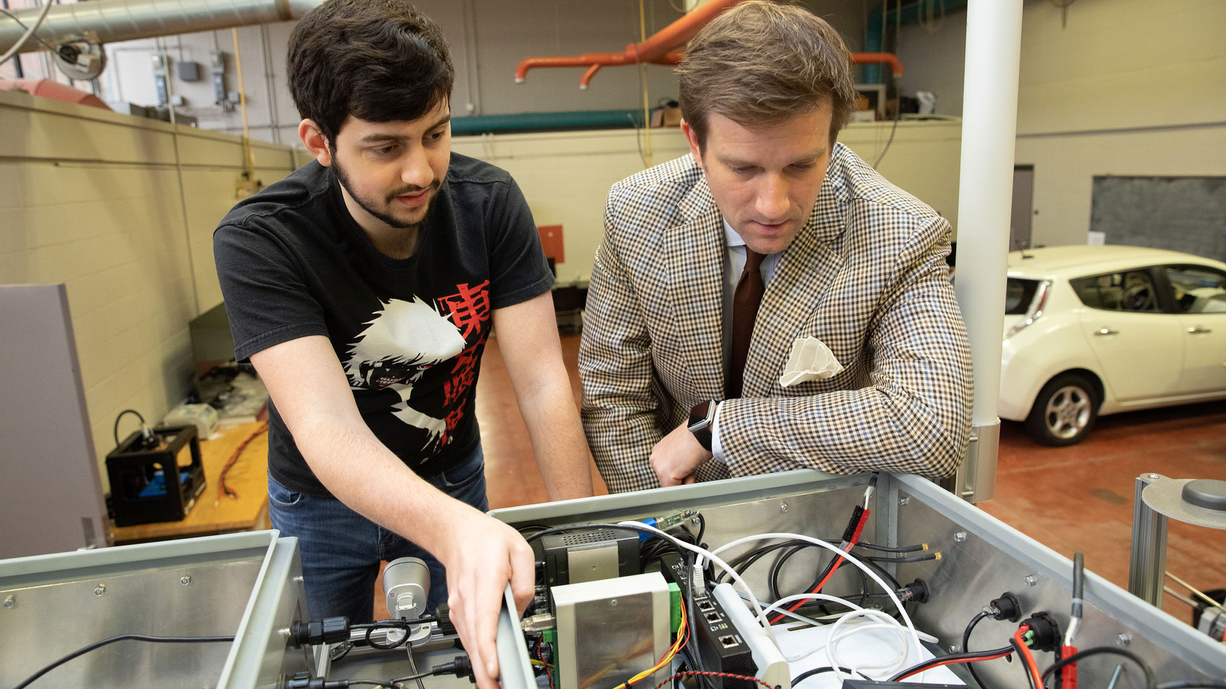 A University of Louisiana at Lafayette student and professor look at a control board while doing engineering research