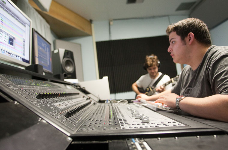 Two University of Louisiana at Lafayette music majors working on a sound mixing board