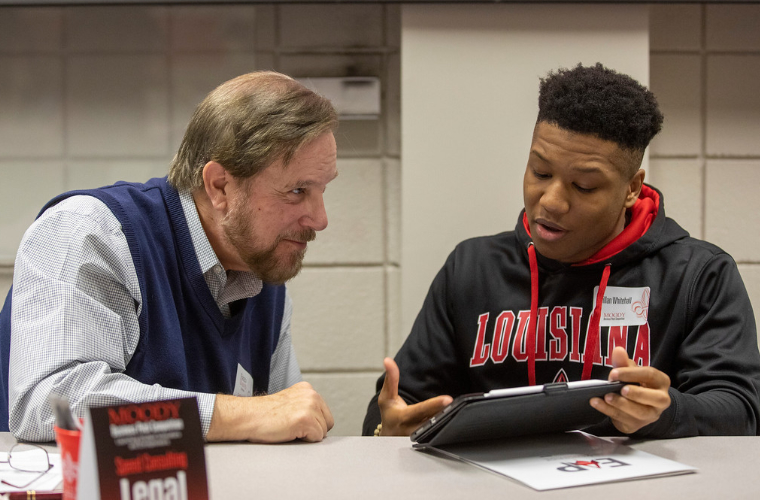 A business student presents his idea for a pitch competition to the professor.