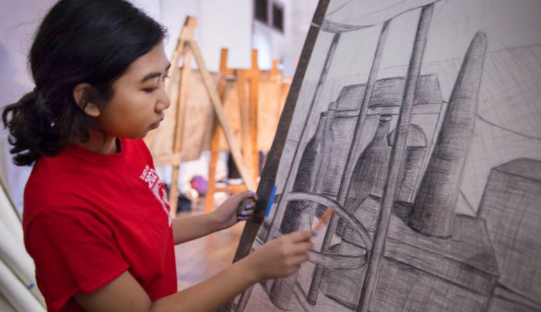 University of Louisiana at Lafayette art major works with charcoal on a canvas
