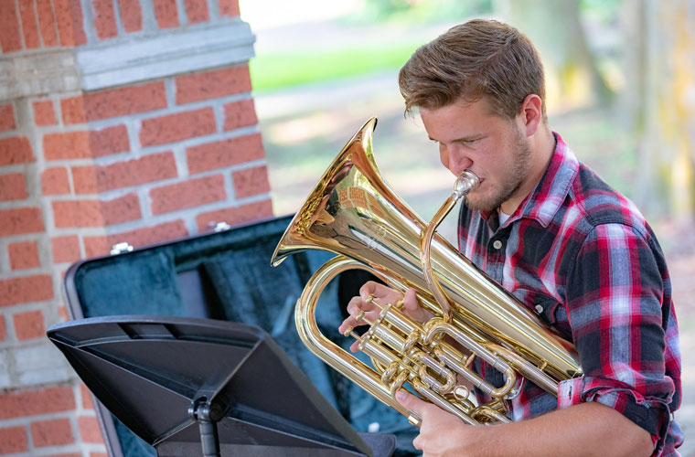 A University of Louisiana at Lafayette instrumental music education major plays his euphonium on campus
