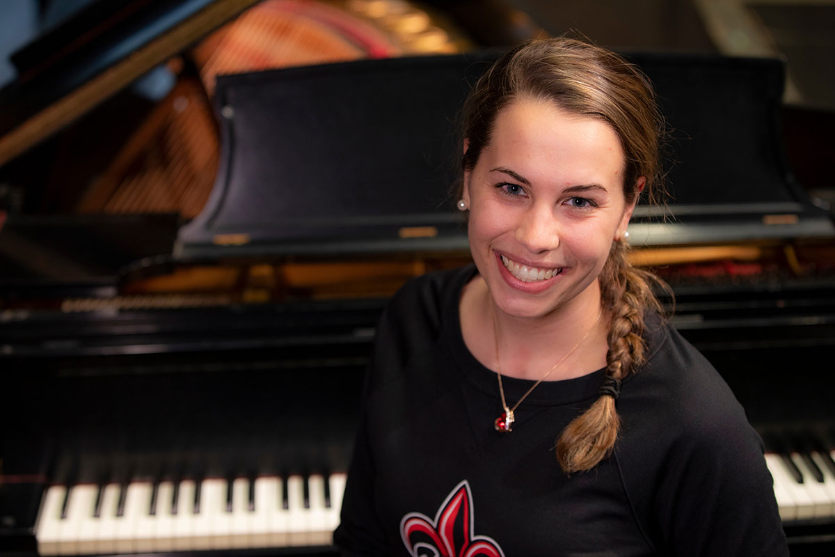 University of Louisiana at Lafayette music education major Katy Meaux sits in front of a piano in an on-campus performance hall