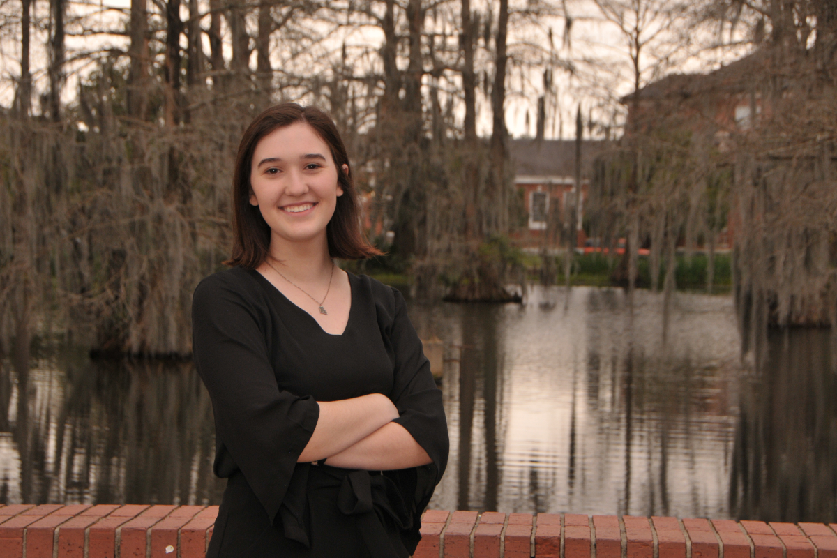 Anthropology alum Regina Lowe stands by the swamp on the University of Louisiana at Lafayette campus.