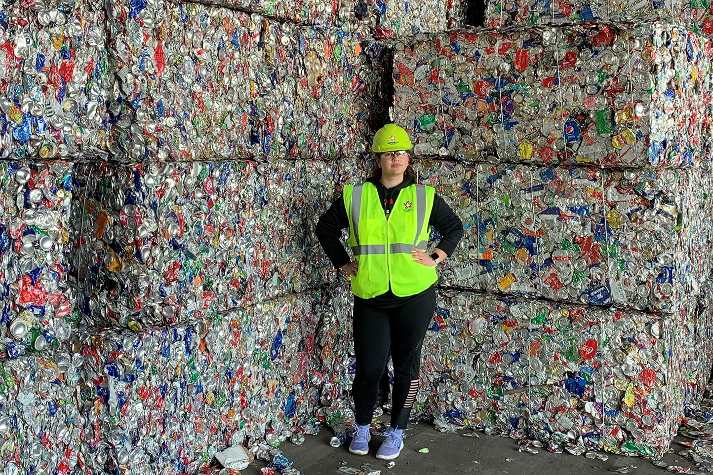 University of Louisiana at Lafayette chemical engineering major Lauren Prudhomme in front of stacks of recycled aluminum cans