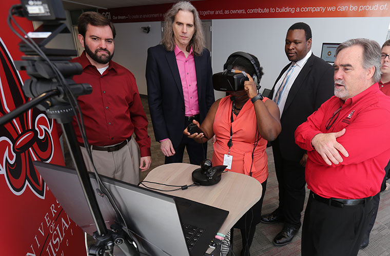 A group of UL Lafayette researchers showing technology solutions to a group of government officials