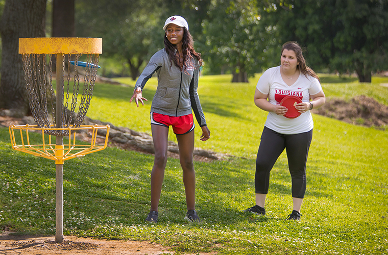 Two University of Louisiana at Lafayette students playing frisbee golf in Girard Park
