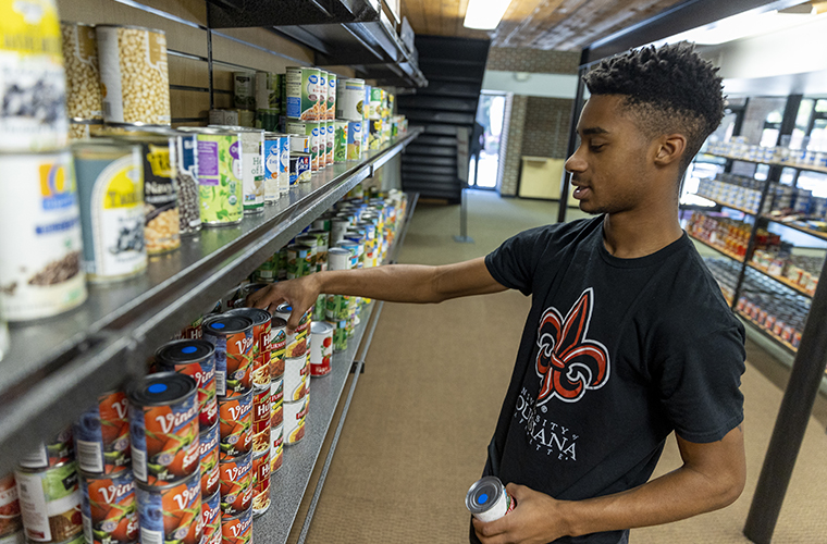 Student stocks shelves at UL Lafayette's Campus Cupboard