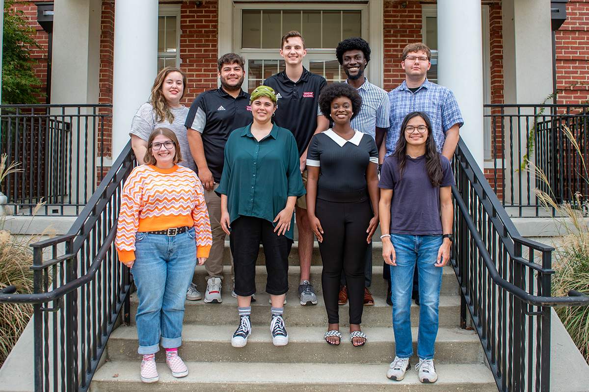 Student leaders of the Vermilion stand together on steps outside of the Vermilion office