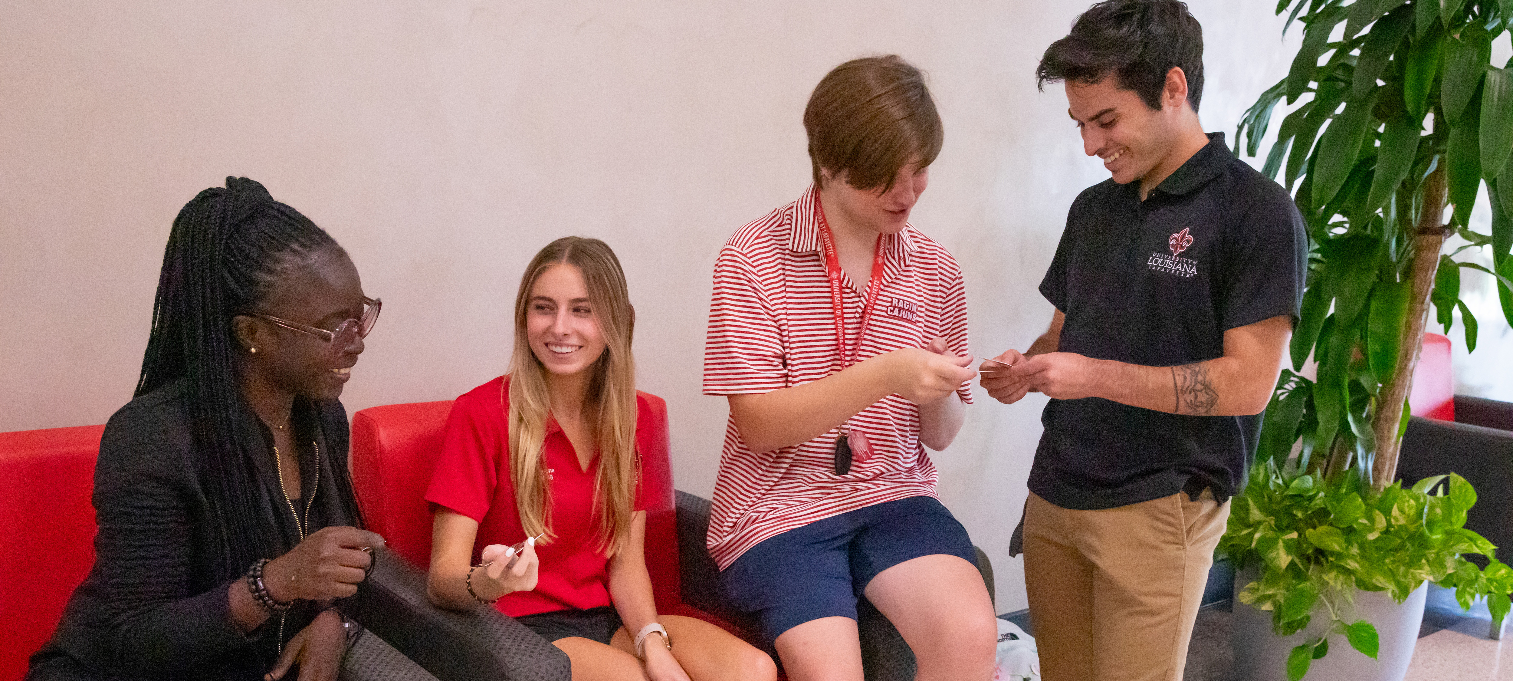 Four students observing their new UL Lafayette Cajun Cards.