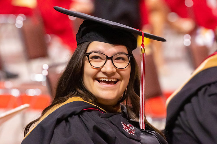 MS in Accounting online graduate Sydney Manuel smiles during commencement ceremonies.