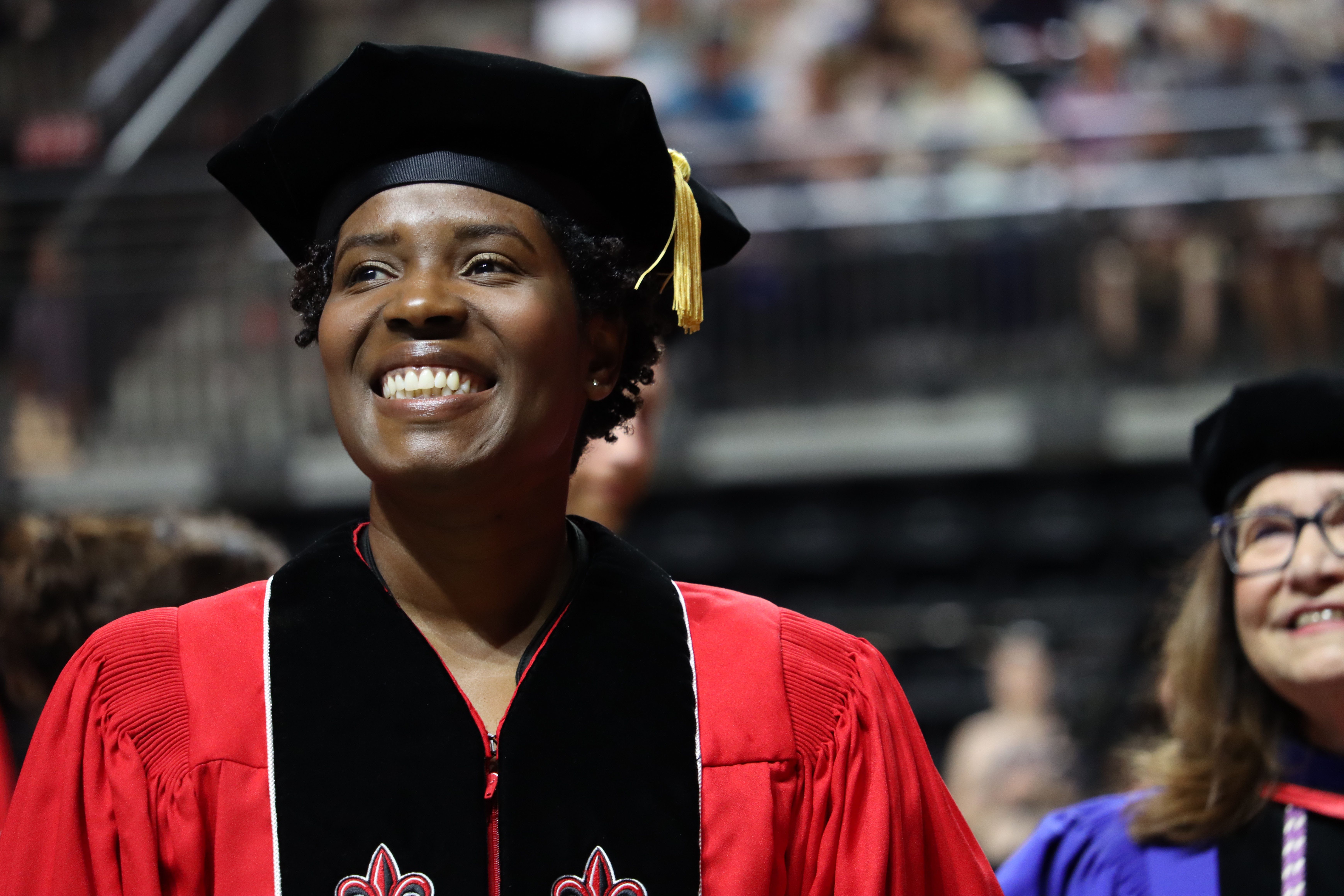 Mecca Daigre, DNP, smiles during UL Lafayette commencement ceremonies in the black and red doctoral regalia.