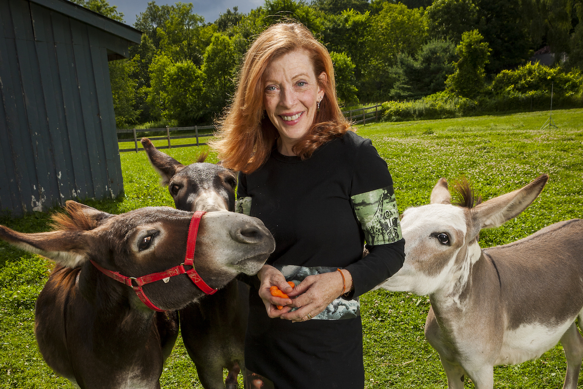 Author Susan Orlean surrounded by three donkeys