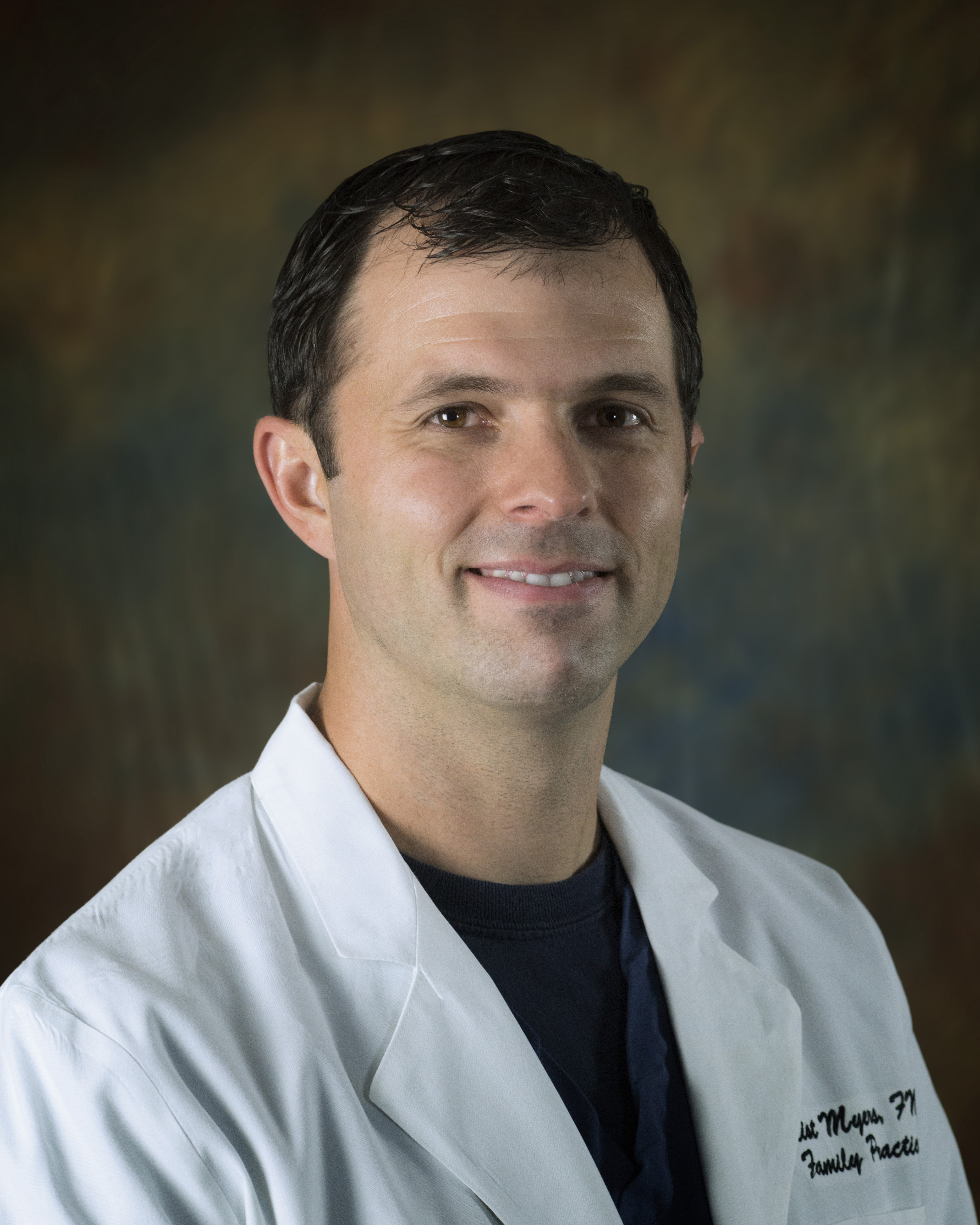 Elliot Myers is pictured in a white lab coat. Myers earned his bachelor's, master's, and doctorate in nursing from UL Lafayette.