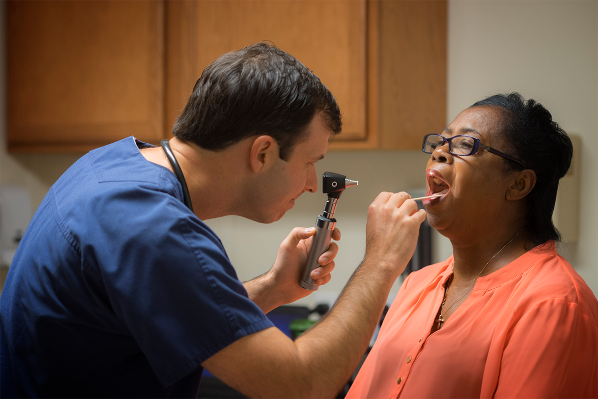 UL Lafayette MS in Nursing alumni and nurse practitioner Elliot Myers examines a patient in his St. Landry Parish clinic.
