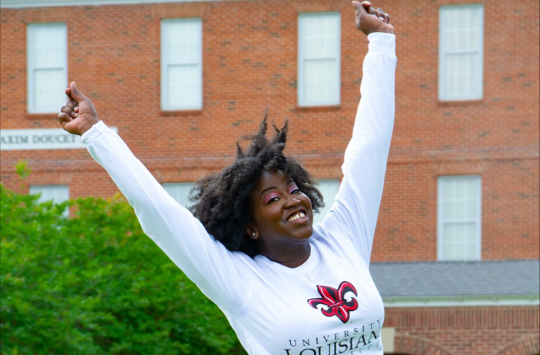 M.Ed. Curriculum & Instruction alumna Jazzmin Evans leaps across the UL Lafayette quad.