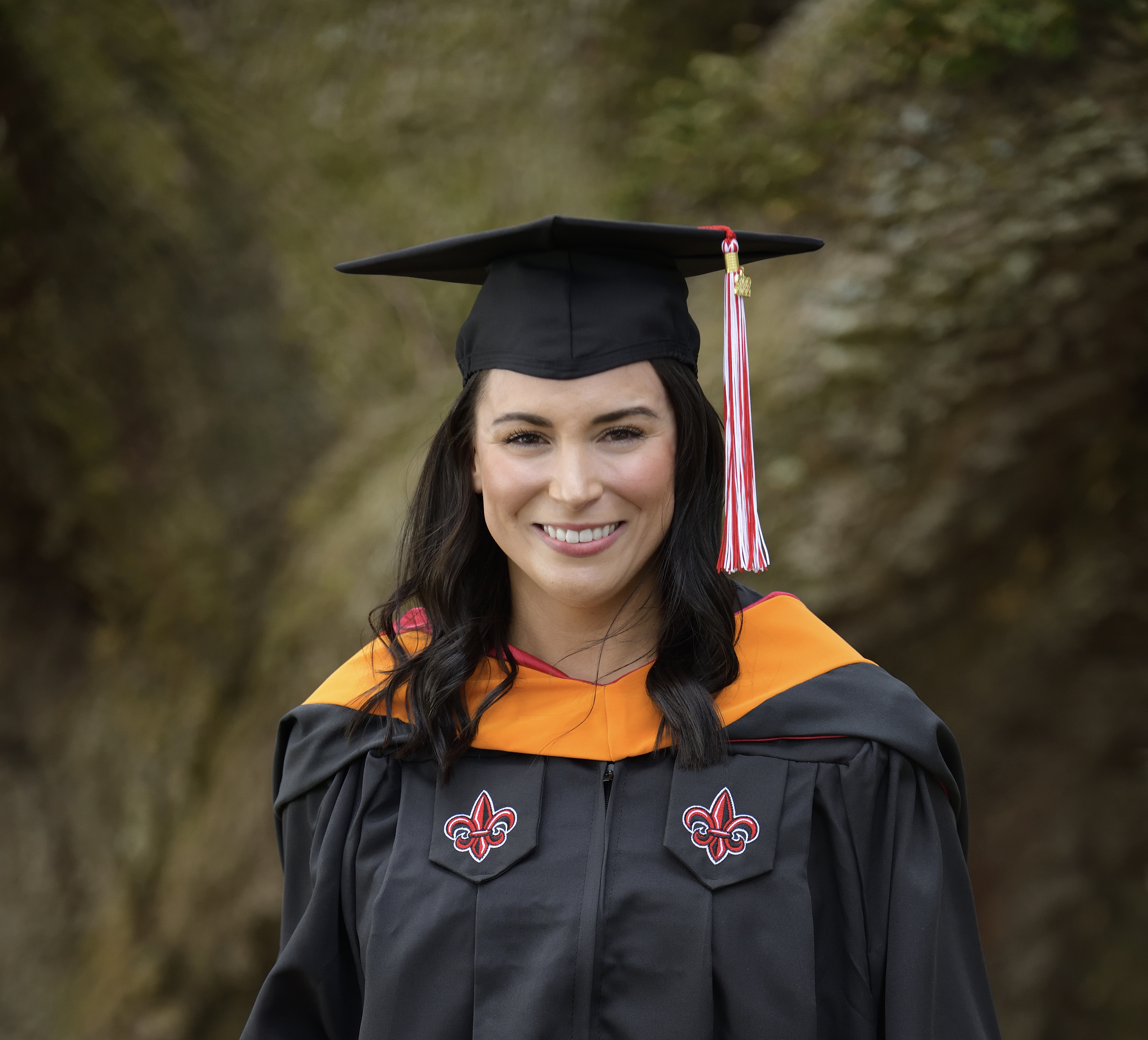 Tabitha Underwood, MSN, is pictured outdoors in a black, UL Lafayette graduate cap and gown.