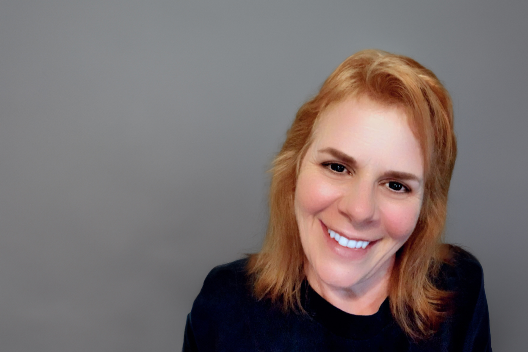 Laurie Martin, MBA student, is pictured in a black shirt on a gray background.