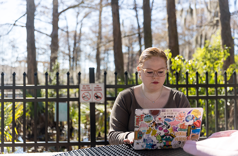 Student on laptop at Cypress Lake