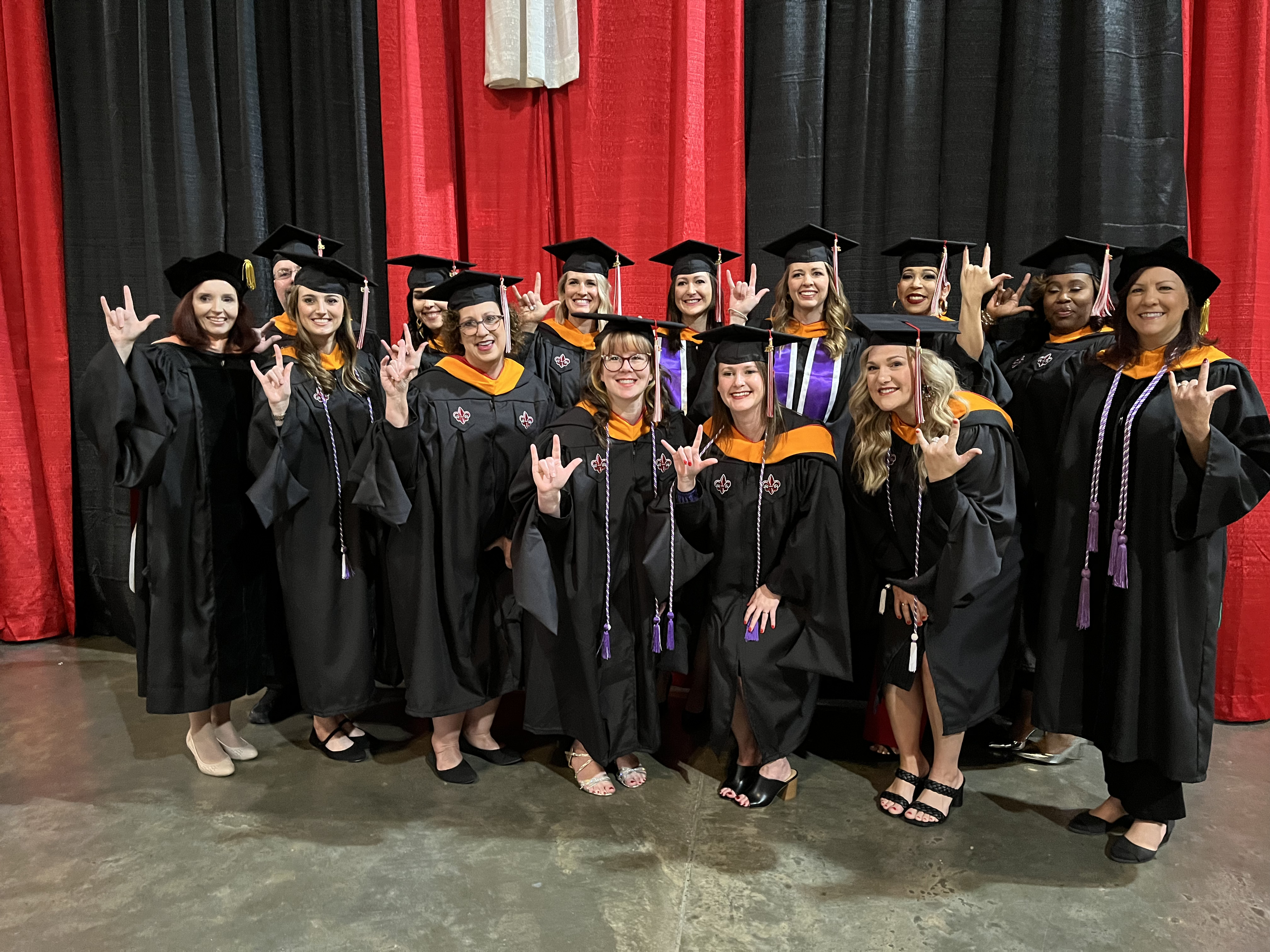 Fall 2023 MSN graduates hold up their hands in the UL Lafayette sign during commencement exercises.
