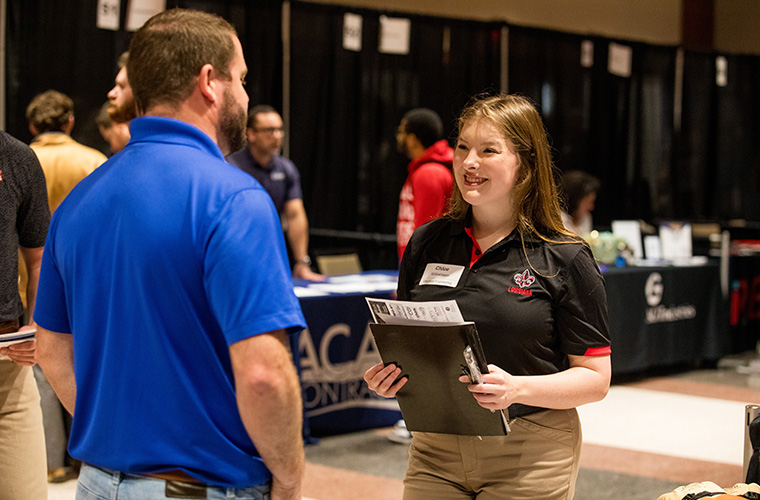 Electrical Engineering student talking to employers at career fair.