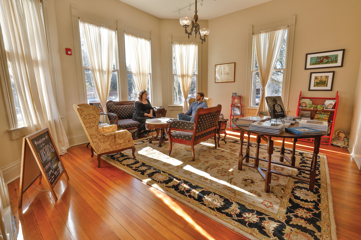 Two graduate students sit in the parlor of the Roy House headquarters of the Center for Louisiana Studies.