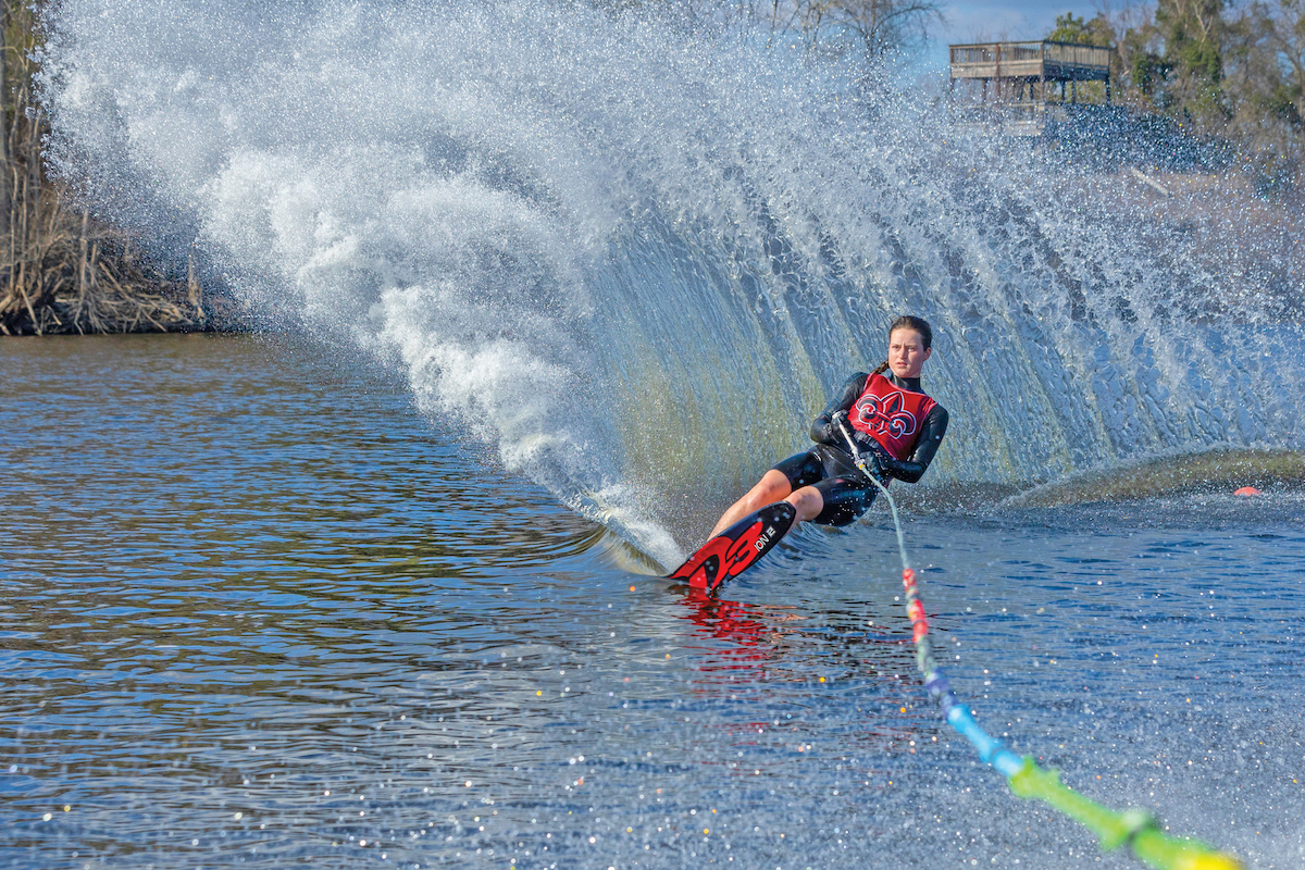 Kennedy Hansen, a junior on the Ragin Cajuns Water Ski Team shoots water into the air from on top her slalom while practicing at airport lake.