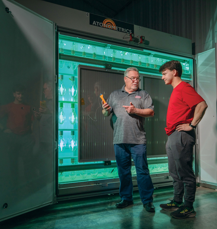 Dr. Terrence Chambers and student researcher Wyatt Stout next to a light-soaking chamber.
