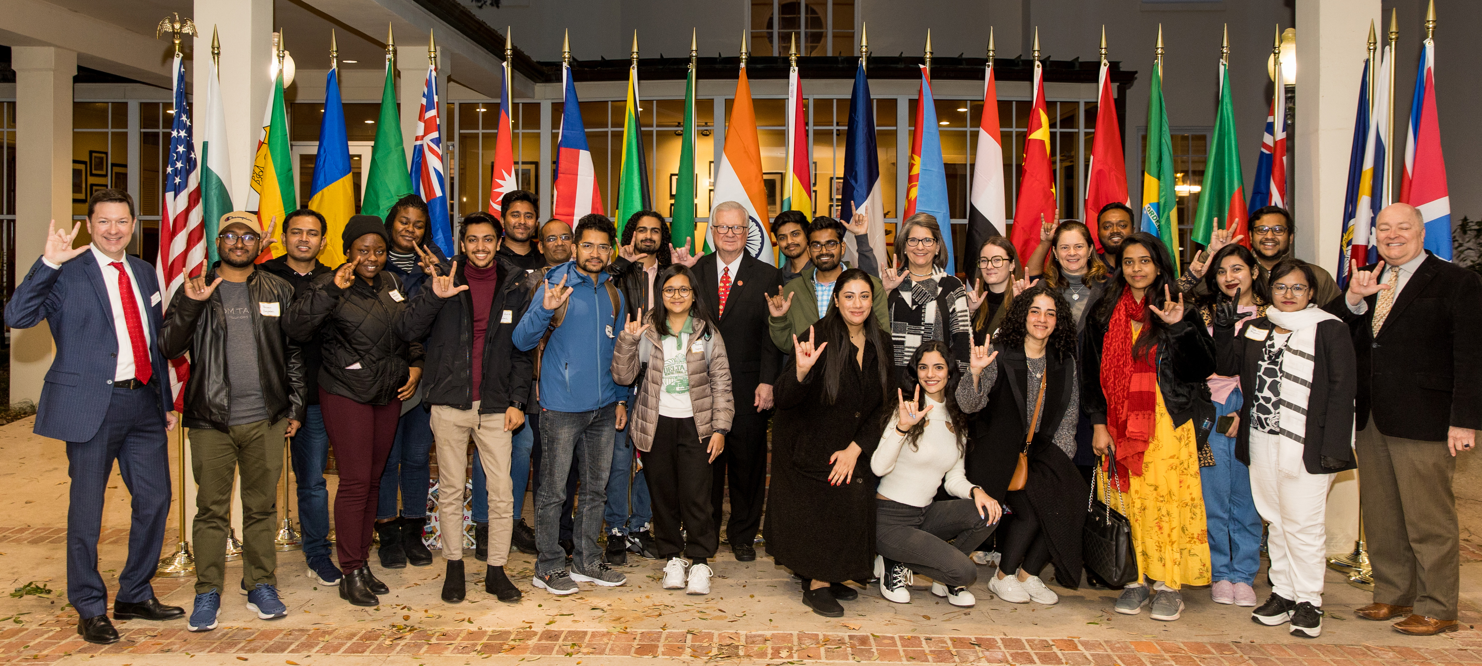 UL Lafayette international students posing in front of international flags.