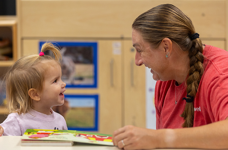 Child Development Center teacher reading with child