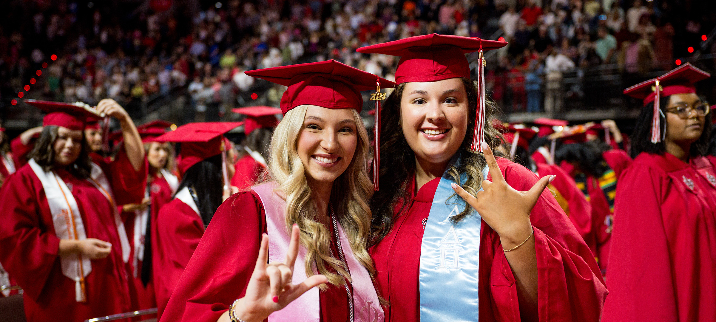 Two students smilling during commencement ceremony