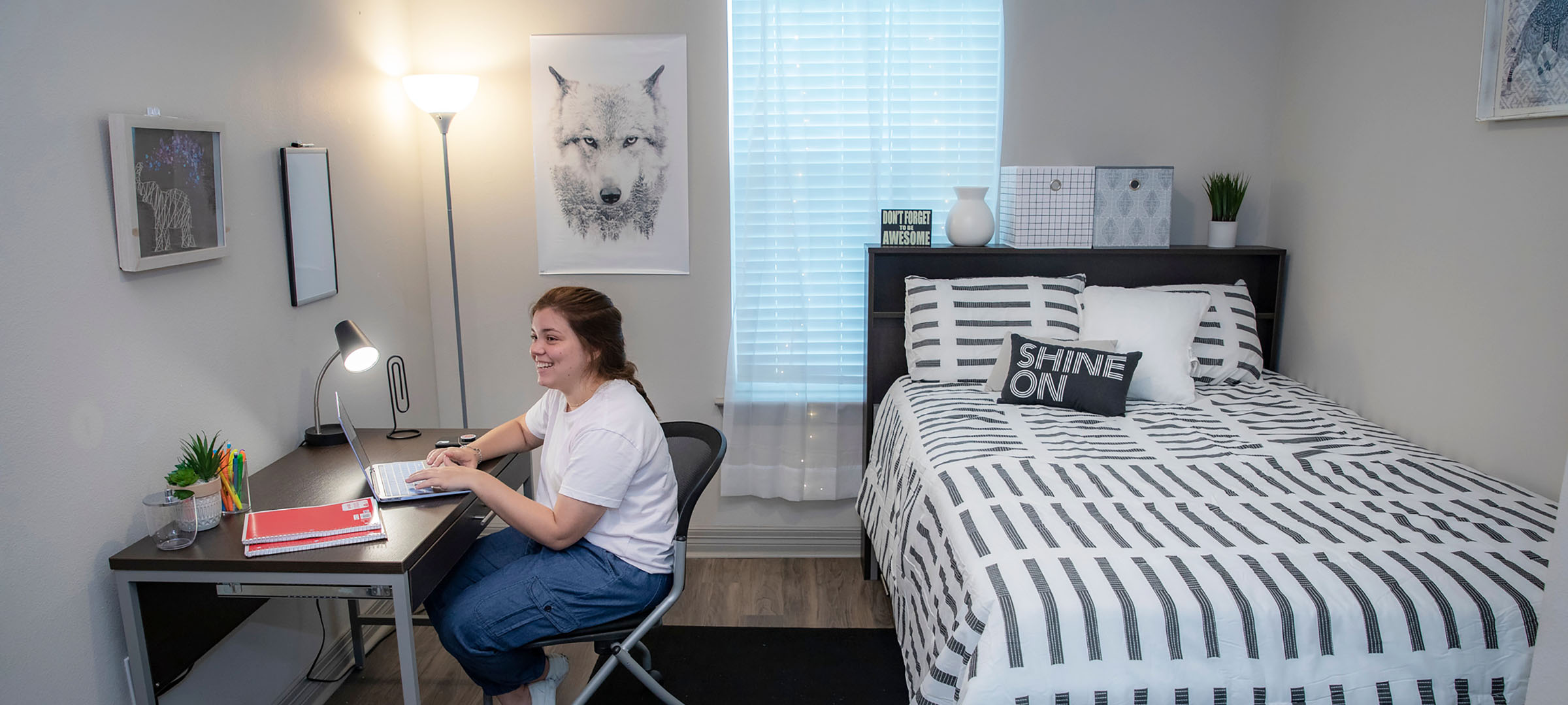 student at laptop in dorm room