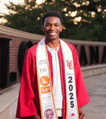 General studies online grad Cameron Theyard smiles in his cap and gown, wearing a stole embellished in his many company logos.