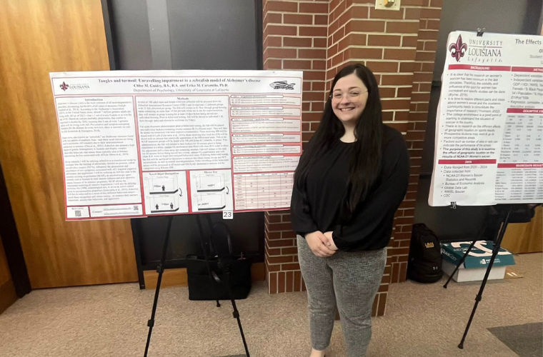 Chloe Guidry standing in front of her research poster at the Research Showcase