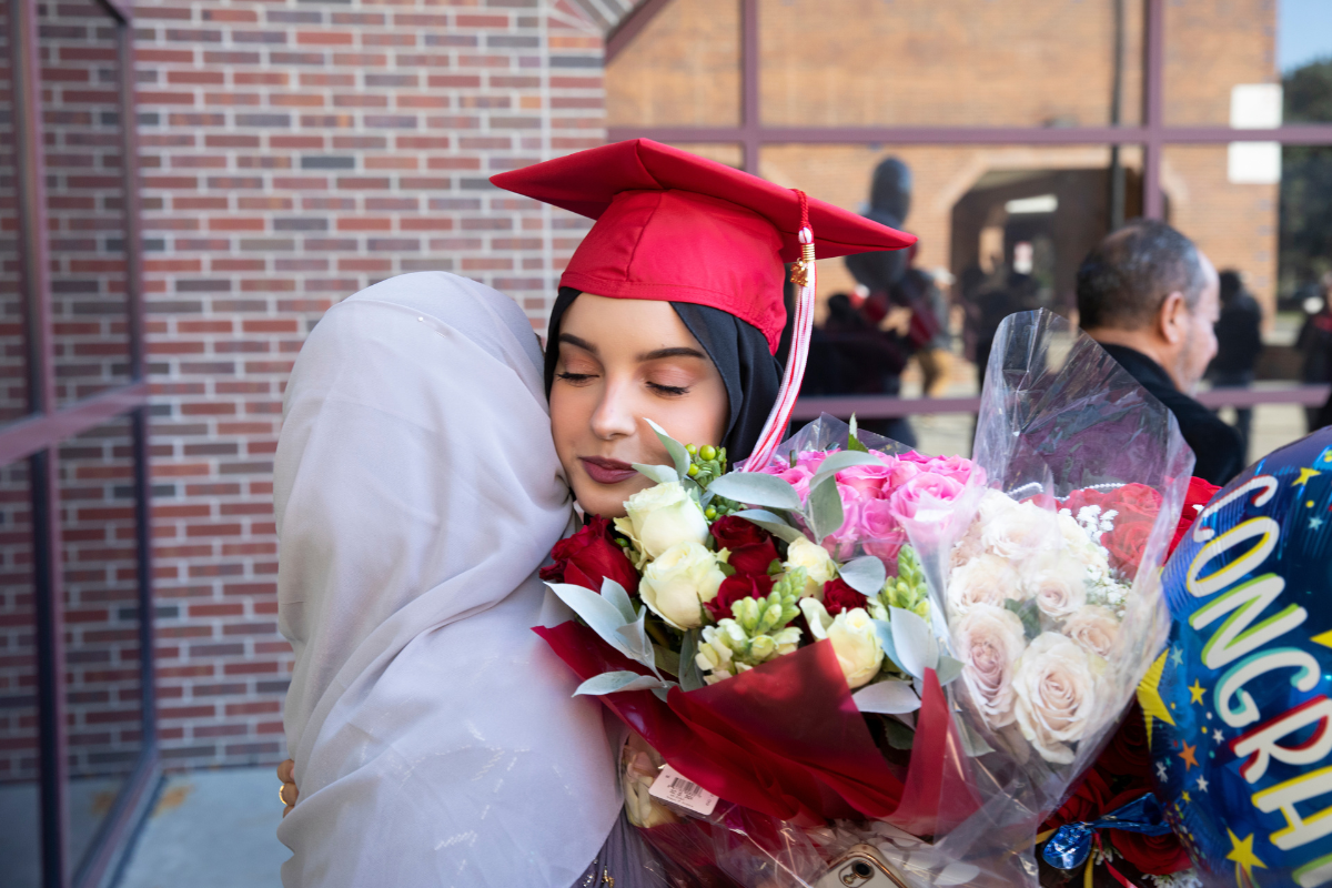 Haneen Muthana hugs family member outside the Cajundome after commencement ceremonies.