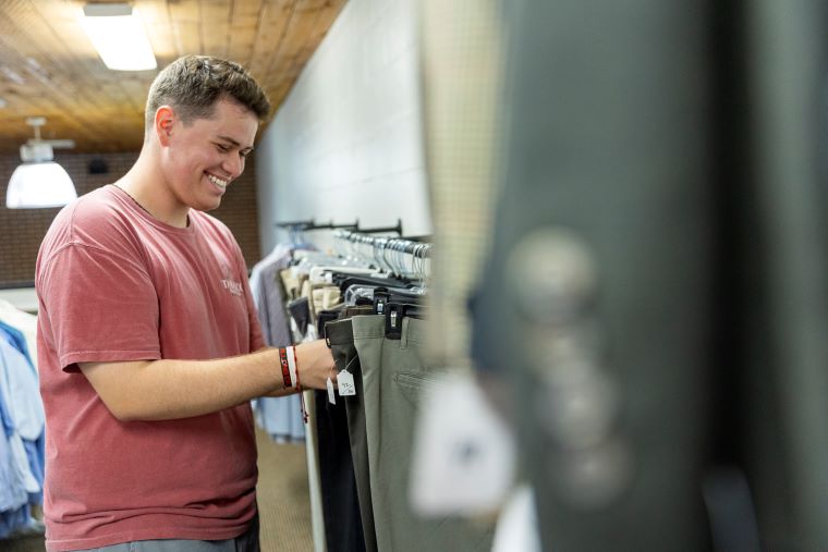 A student browses dress pants at the Career Closet 