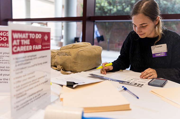 A UL Lafayette chemical engineering student filling out information at a career fair.