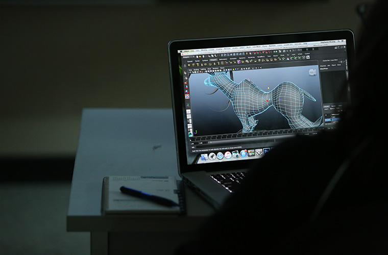 View of a computer screen from behind a UL Lafayette computer art and animation student featuring an animation modeling program.