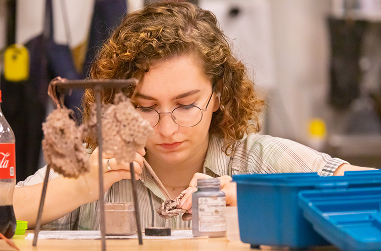 UL Lafayette visual arts student working on a metalwork casting to turn into jewelry.