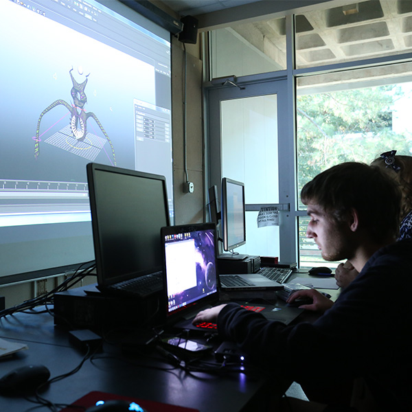 UL Lafayette student working on a computer with a screen showing computer animation software ahead.
