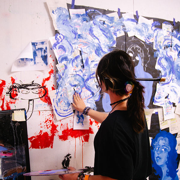 UL Lafayette student painting a large blue piece.