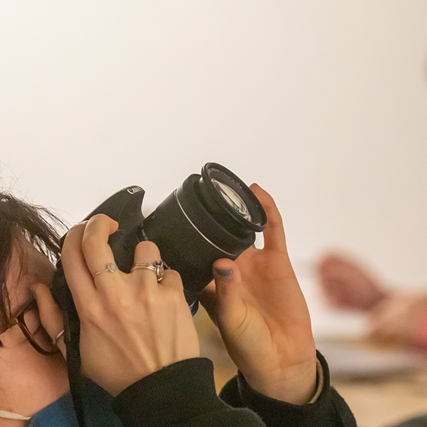 UL Lafayette photography student looking up through a camera lens.