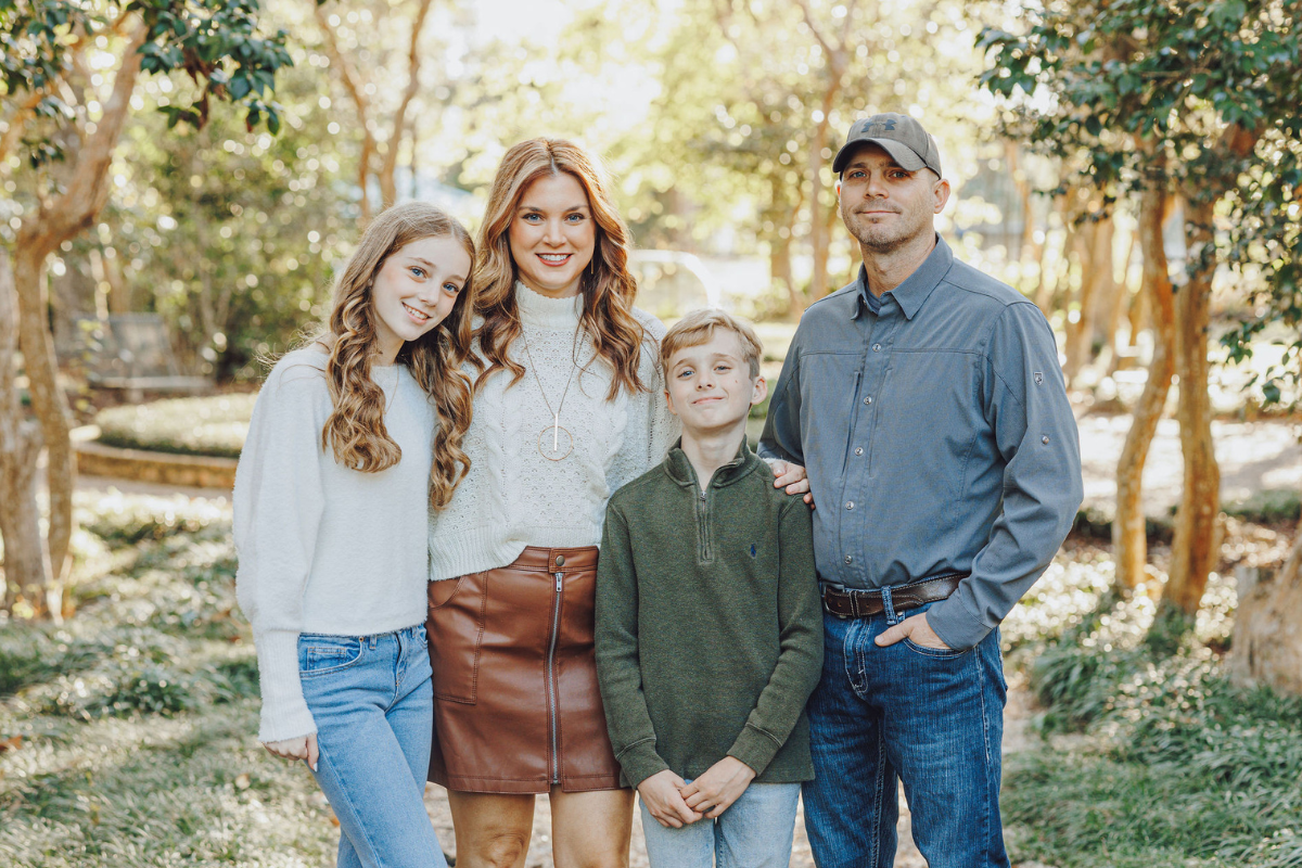 Alumni of the online master's in informatics program smiles with her husband, son, and daughter. 