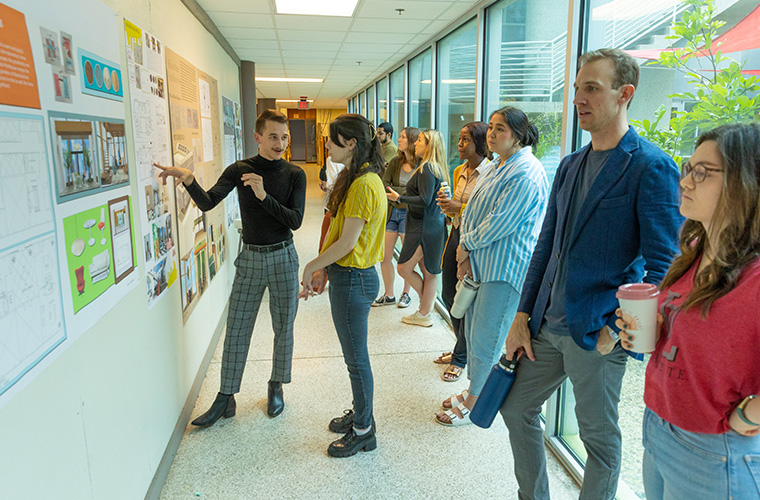 UL Lafayette interior design examining and critiquing a wall of design options