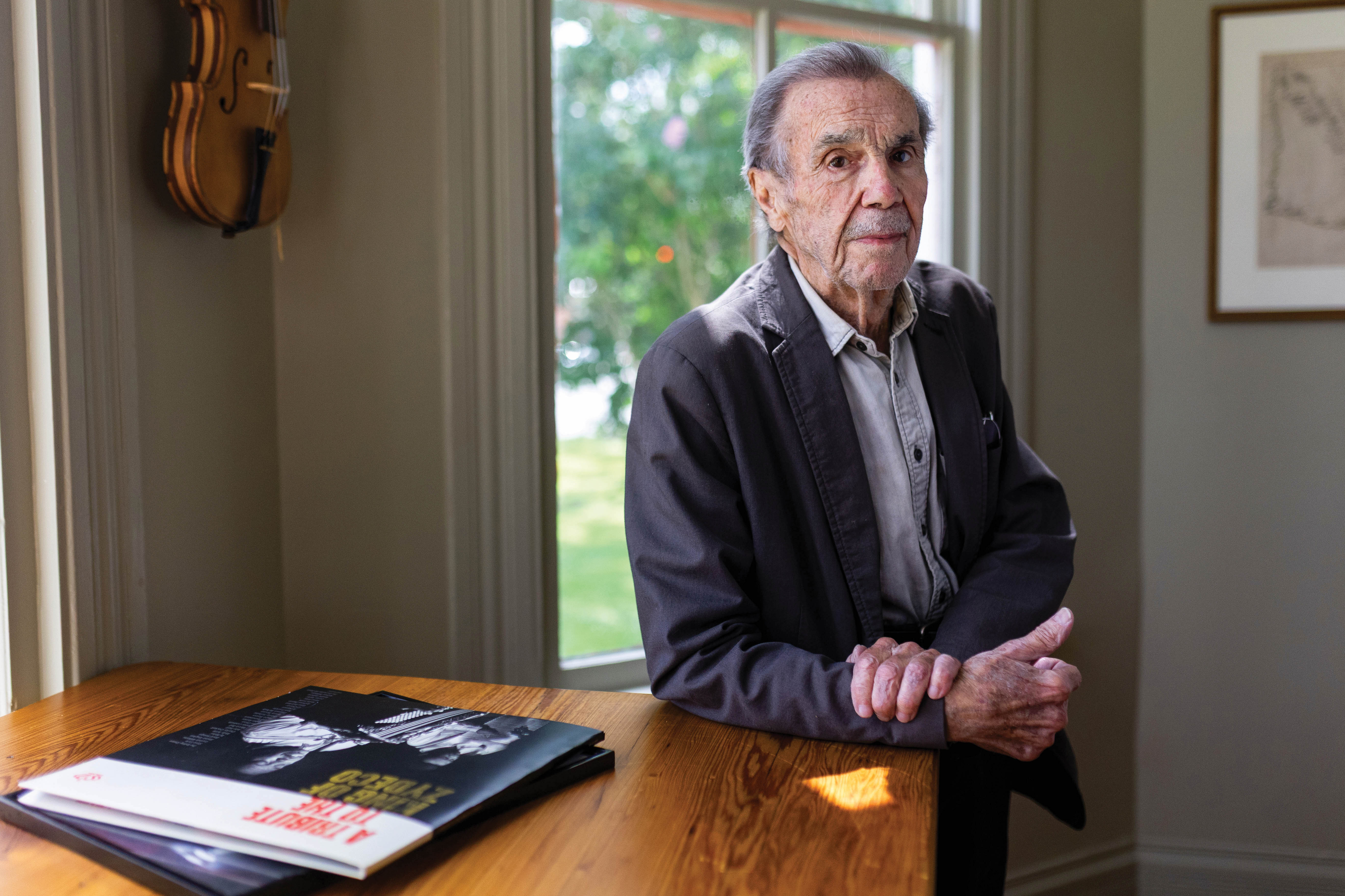 Dickie Landry rests on a table in the Roy House with a copy of the Clifton Chenier tribute album in the foreground.