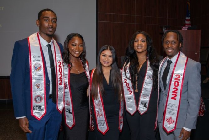 LEP students wearing decorative graduation stoles pose at an event