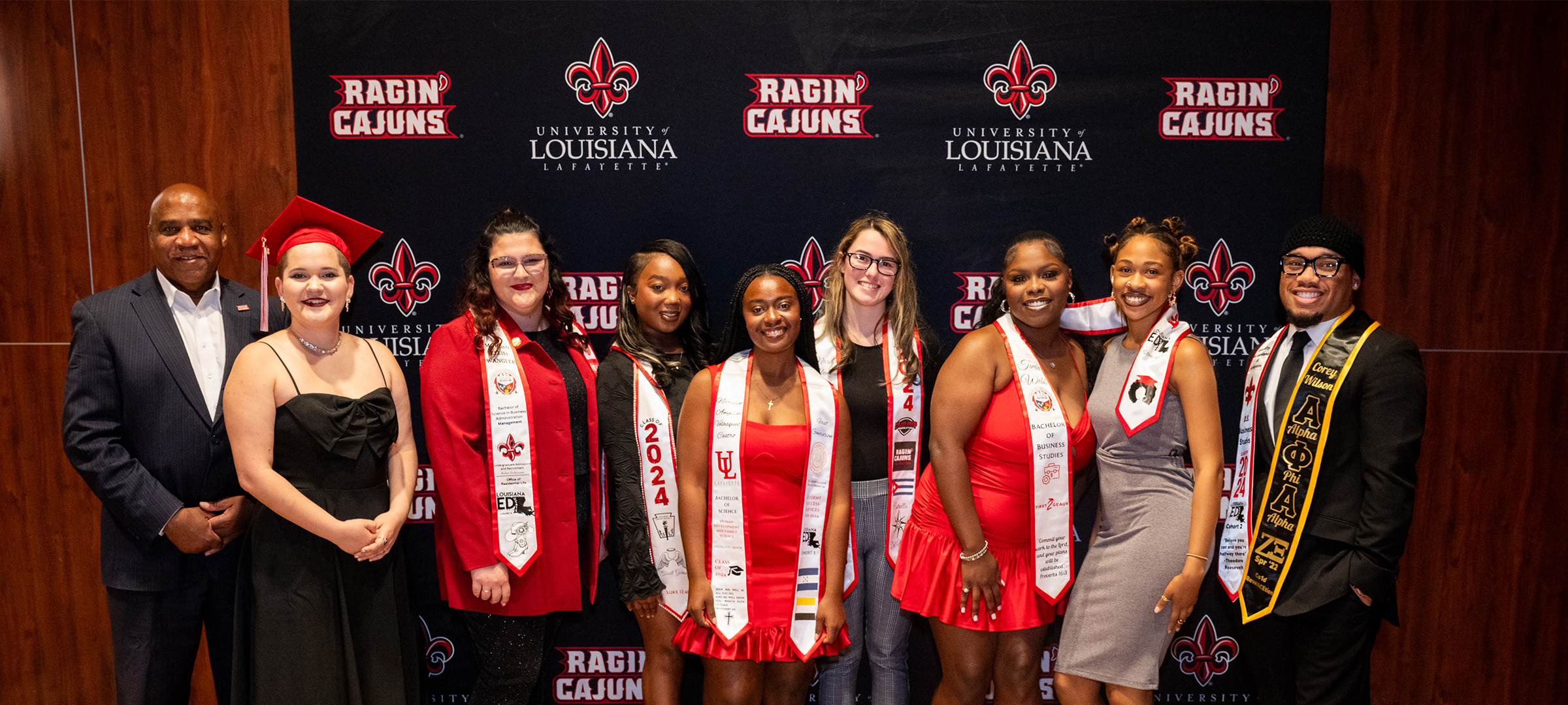 A group of LEP graduates wearing graduation stoles pose with Dr. DeWayne Bowie