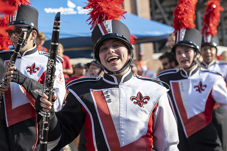 UL student in marching band smiles while holding her clarinette